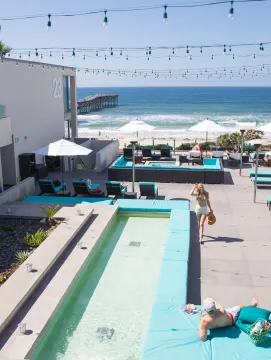Couple enjoying the pool overlooking the Pacific Ocean at a hotel in San Diego